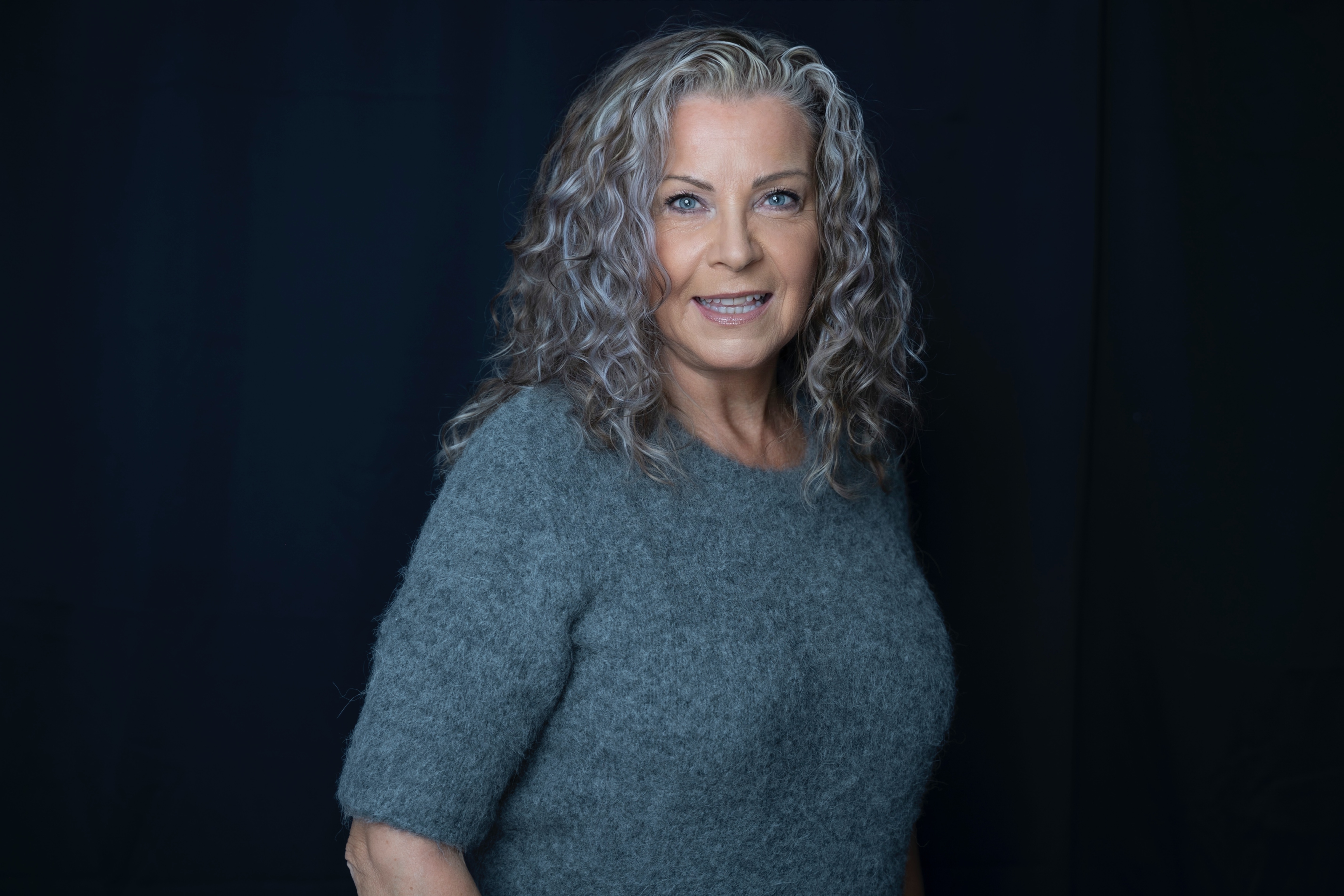 Michelle Dandenell i grå tröja mot mörk bakgrund